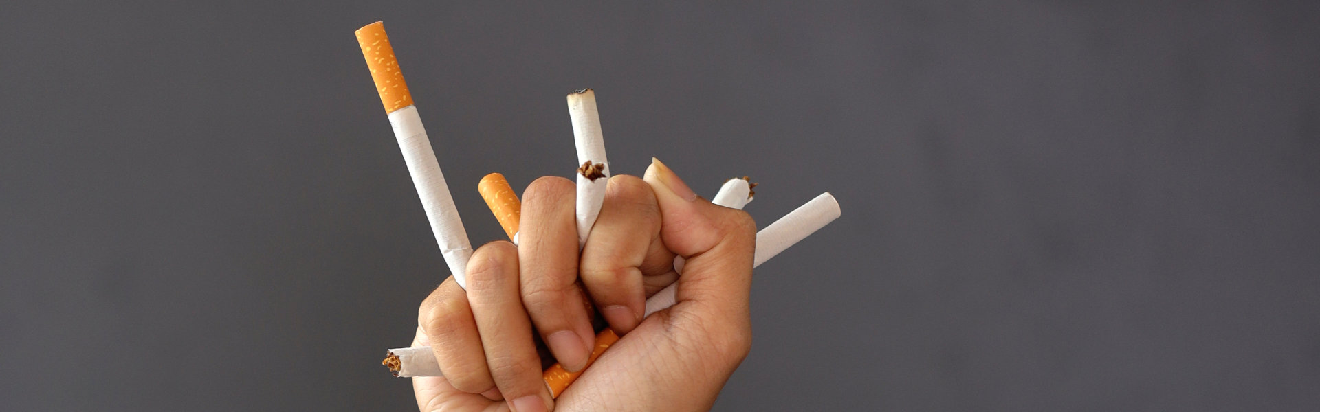 Hand crushing cigarettes. Concept of quitting smoking